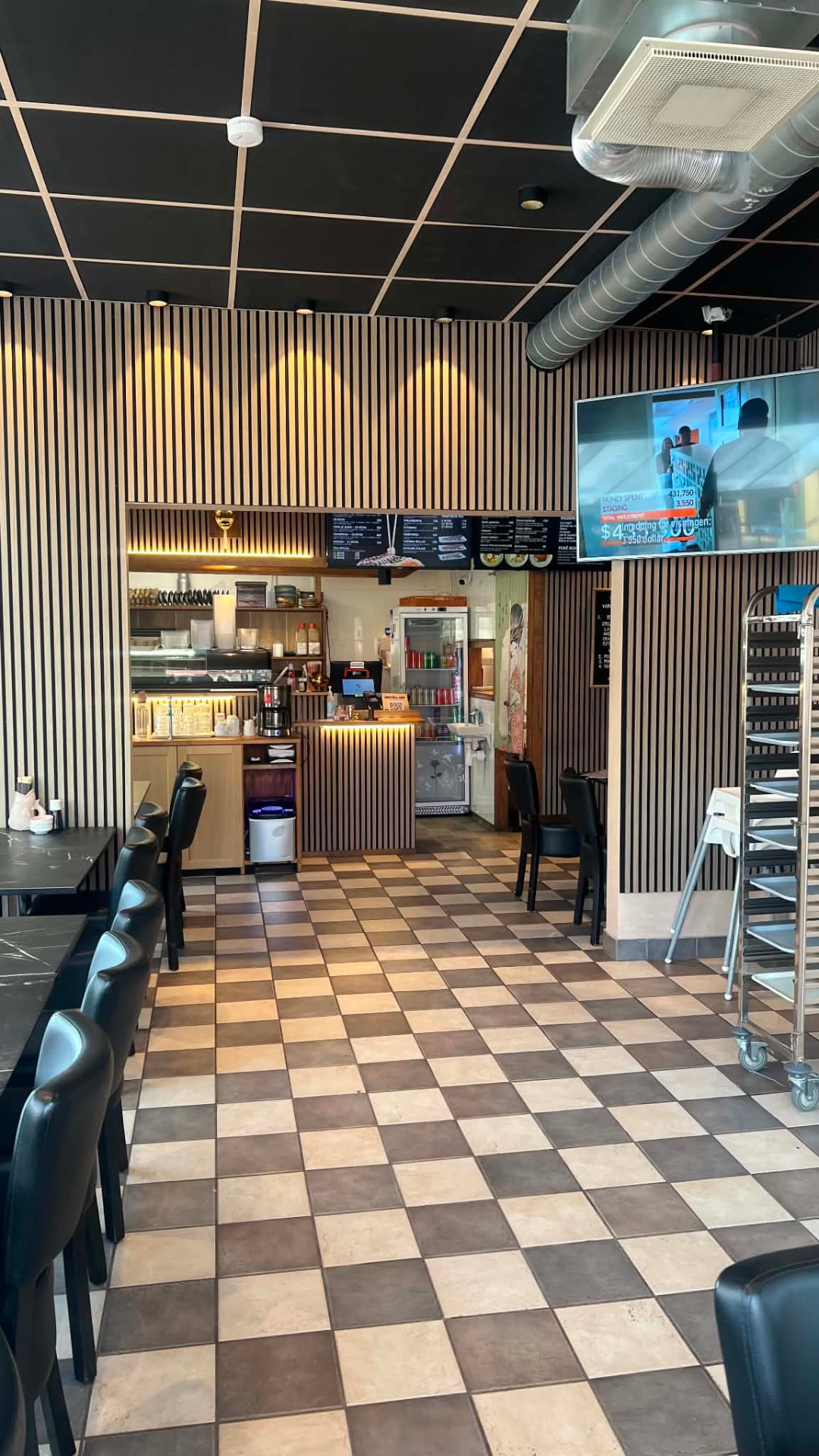 Restaurangens matsal med bord, bardisk och menyskärmar